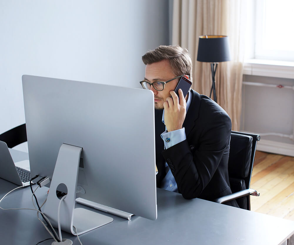 investorade partner using computer while talking on thew phone
