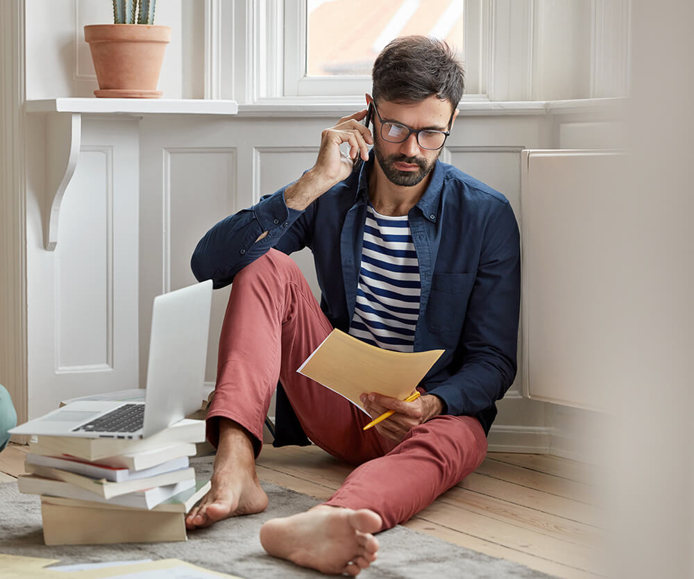 man talking on the phone while looking at document